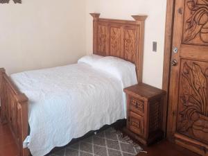 a bedroom with a bed and a wooden cabinet at OYO Los Alcatraces in Tzintzuntzán