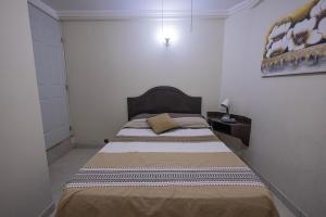 ein Schlafzimmer mit einem großen Bett in einem Zimmer in der Unterkunft Capital O Hotel Patio Pombo in Oaxaca de Juárez
