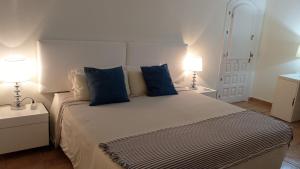 a bedroom with a large bed with blue pillows at Villa Tranquilla in Estepona