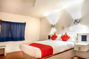 a bedroom with a large bed with red pillows at OYO Posada Astrud,Cuetzalan in Cuetzalán del Progreso