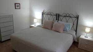 a bedroom with a large white bed with two lamps at Villa Tranquilla in Estepona