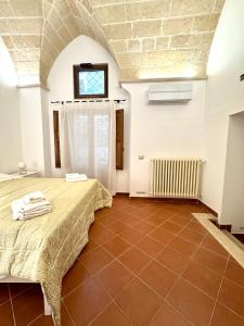 een slaapkamer met een bed en een bakstenen muur bij Casa Ginevra, private Parking in Lecce