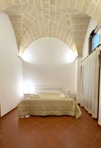 een slaapkamer met een bed en een stenen plafond bij Casa Ginevra, private Parking in Lecce