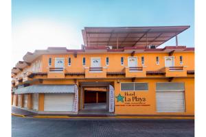 un gran edificio naranja con un tercer garaje en OYO Hotel La Playa, en Zihuatanejo
