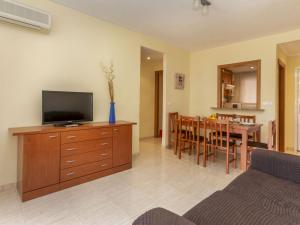 a living room with a television on a dresser and a dining room at Apartment Playa Coral I-1 by Interhome in Oropesa del Mar