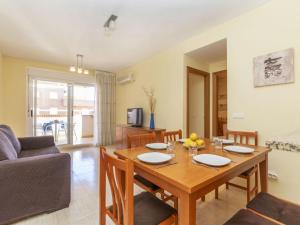 a living room with a wooden table and a couch at Apartment Playa Coral I-1 by Interhome in Oropesa del Mar +18 photos