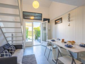 a living room with a table and chairs and a staircase at Holiday Home Les Jardins de l'Océan-38 by Interhome in Pontaillac