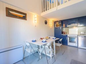 a kitchen with a white table and chairs at Holiday Home Les Jardins de l'Océan-38 by Interhome in Pontaillac