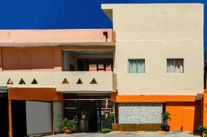 an apartment building with an orange and white facade at OYO Hotel Cabo Del Sur, Cabo San Lucas in Cabo San Lucas