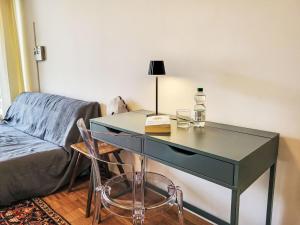 a desk with a lamp and a book and a chair at Apartment App- Castausio 26 by Interhome in Lugano
