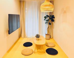 a living room with a table and a tv at 新上双卧套房 最大5人 设计师风格Yaof 东京中心上野公园3分钟 车站1分钟 位置极佳超级繁华 房间内看樱花 in Tokyo
