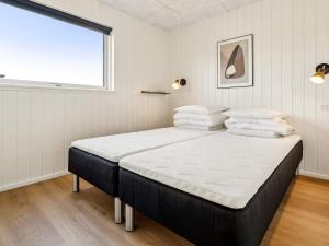 a bedroom with a bed with white sheets and a window at 5 star holiday home in Otterup in Otterup +37 photos
