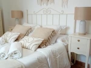 a white bed with white sheets and pillows on it at Casa El Azud La Cañada 1 minuto metro in Partida de La Cañada