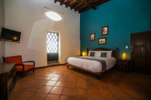 a bedroom with a bed and a blue wall at Collection O Al otro lado del rio, Puebla in Puebla +36 photos