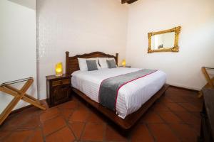 a bedroom with a bed and a mirror on the wall at Collection O Al otro lado del rio, Puebla in Puebla