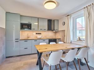 - une cuisine avec une table en bois et des chaises blanches dans l'établissement Holiday Home Holiday Hill 40 by Interhome, à Černý Důl