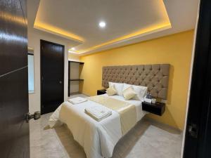 a hotel room with two beds with white sheets at OYO Hotel Familiar Tollan Cholula in Cholula