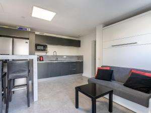 a living room with a couch and a kitchen at Apartment Cap Négre - Domaine de la Pinède-9 by Interhome in Le Lavandou +21 photos