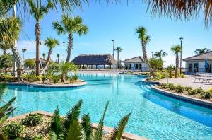 a swimming pool with palm trees in a resort at Luxury Champions Gate Condo, Resort-Style Retreat in Kissimmee