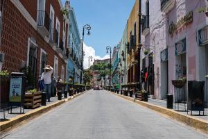 una persona parada en una calle en una ciudad en Casona Poblana Hotel Puebla, en Puebla 63 fotos más