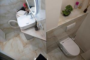 Un baño con un inodoro blanco y un lavabo. en New Stylish Place for Couple, en Bratislava 3 fotos más