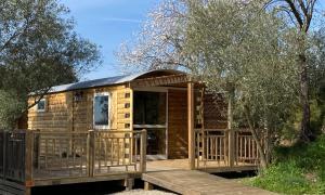 a log cabin with a porch and a deck at Camping Les Amandiers in Castelnau-de-Guers