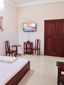a bedroom with a bed and a tv on a wall at Khách sạn Dạ Lan in Ðông Hòa +14 photos