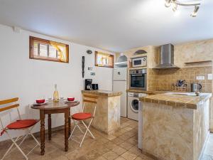 a kitchen with a table and a small table with chairs at Apartment Mimosas by Interhome in Carqueiranne