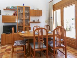 a dining room with a wooden table and chairs at Villa Palmera I by Interhome in L'Ametlla de Mar