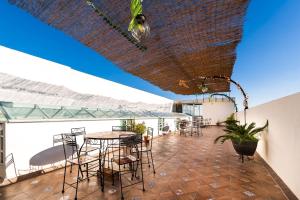 a patio with tables and chairs on a roof at Capital O Hotel Joyma Suites, San Luis in San Luis Potosí