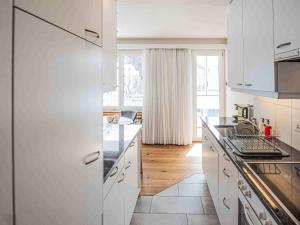 a kitchen with white cabinets and a counter top at Apartment Chesa Fleury by Interhome in St. Moritz