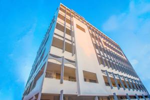 a white building with a blue sky in the background at Sri Ramakrishna Hotel in Bangalore
