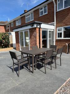 a table and chairs in front of a brick building at Modern & Spacious Home in Exeter - Smart TV & Xbox in Pinhoe