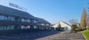 プレジールにあるHotel Pavillon des Gatinesの前に駐車場がある建物