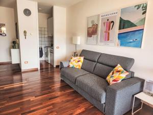 sala de estar con sofá gris y suelo de madera en Studio By the lake by Interhome, en Lesa