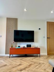 a living room with a tv on a wall at Luxury Coastal Cottage in Portsoy