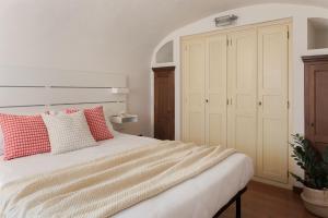 a bedroom with a bed with red and white pillows at Il nido di Cate in Fossano
