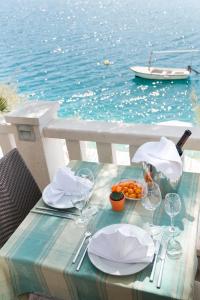 a table with plates of food and a boat in the water at Hotel Villa Nova in Neum