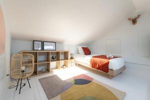 een slaapkamer met een bed, een stoel en een tapijt bij OIQIA • Air Nomad • Vancouver in Valenciennes