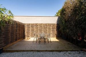een tafel en stoelen op een houten patio bij OIQIA • Air Nomad • Vancouver in Valenciennes