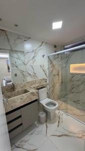 a bathroom with a toilet and a sink and a shower at Flat luxury hotel cove in Maceió +10 photos