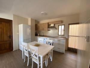 a kitchen with a table and chairs and a refrigerator at La Casa de Domingo in Tózar