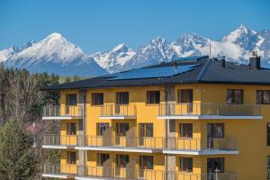 a building with solar panels on the roof with mountains in the background at Hotel Galica in Vrbov