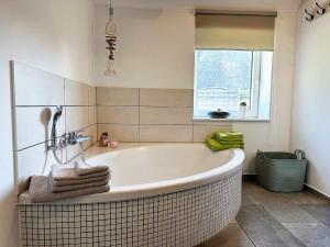 a bath tub in a bathroom with a window at Ferienhaus Fresen Hus Humptrup in Humptrup