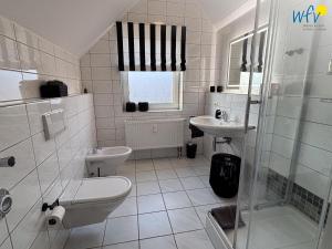une salle de bain avec toilettes, lavabo et douche dans l'établissement Haus Nordstern Ferienwohnung Hummerhütte, à Juist 17 autres photos
