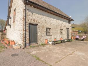 a brick building with a bench in front of it at Tipyn Bach in Caerphilly