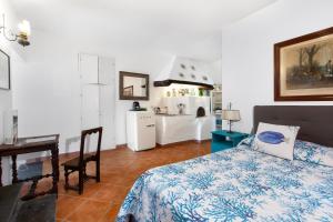 a bedroom with a bed and a table and a kitchen at Gaiano Apt in Sorrento