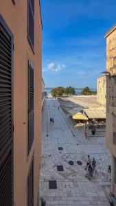 Blick auf einen Strand mit Menschen auf Bänken in der Unterkunft Luxury Rooms - FOR GIFT in Zadar