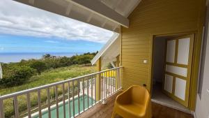 卡佩斯特Villa Boréale的阳台的黄色椅子,享有海景