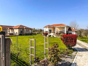 a fence in front of a yard with houses at Charming Countryside Villa with Garden & Terrace near Skadar Lake in Berislavci